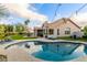 Resort-style backyard featuring a sparkling pool, lounge chairs, mature landscaping, and a covered patio with BBQ at 2040 E Indigo Brush Rd, Phoenix, AZ 85048