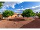 A serene backyard featuring mature shade trees, stone landscaping and a cozy patio. Perfect for relaxation and enjoyment at 2148 E Cairo Dr, Tempe, AZ 85282