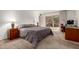 This bedroom features a cozy bed with a patterned comforter, a study desk, and natural light from the sliding doors at 2148 E Cairo Dr, Tempe, AZ 85282