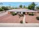 Beautiful home with stone landscaping, manicured bushes, an American flag, and a welcoming walkway at 2148 E Cairo Dr, Tempe, AZ 85282