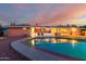 Inviting backyard pool with a patio, lounge chairs, and an orange house exterior reflecting the sunset's glow at 2148 E Cairo Dr, Tempe, AZ 85282
