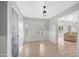 Bright entryway featuring hardwood floors, a stylish light fixture, and a 'Welcome Home' chalkboard door at 222 N Miller St, Mesa, AZ 85203