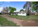Charming white home with spacious front yard and mature trees providing shade and curb appeal at 222 N Miller St, Mesa, AZ 85203
