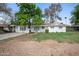 Charming white home with well-manicured lawn and mature trees offering a picturesque curb appeal at 222 N Miller St, Mesa, AZ 85203