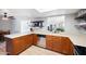 Kitchen with stainless steel appliances and wood cabinets, complemented by floating shelves and view to dining area at 222 N Miller St, Mesa, AZ 85203