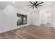 Open living room with wood flooring, large windows, and a modern ceiling fan at 226 W Ranch Rd, Tempe, AZ 85284