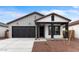 Charming single-story home with a black garage door and desert landscaping at 23403 W Albeniz Pl, Buckeye, AZ 85326
