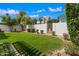 Grassy backyard enclosed by white fencing with metal gate, offering a private outdoor space at 2436 E Elm St, Phoenix, AZ 85016