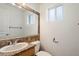 Bathroom with stone tile framed mirror, granite countertop, sink, toilet, towel rack, and window at 2436 E Elm St, Phoenix, AZ 85016