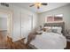 Bright bedroom featuring a ceiling fan, window, wood flooring, and a comfortable bed with stylish headboard at 2436 E Elm St, Phoenix, AZ 85016