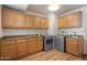 Spacious laundry room featuring wood cabinets, granite countertops, stainless steel washer, and dryer at 2436 E Elm St, Phoenix, AZ 85016