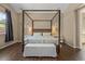 Bedroom featuring a four-poster bed, neutral walls, and wood-look floors at 2926 E Minnezona Ave, Phoenix, AZ 85016