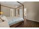 Bedroom showcasing a four-poster bed, neutral walls, and wood-look floors at 2926 E Minnezona Ave, Phoenix, AZ 85016