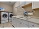 Bright laundry room with modern washer, dryer and white cabinetry at 2926 E Minnezona Ave, Phoenix, AZ 85016