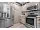 Updated kitchen with stainless steel refrigerator and stove, paired with white countertops and backsplash at 3104 E Broadway Rd # 170, Mesa, AZ 85204