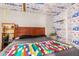 Bedroom with exposed insulation, a colorful quilt, and a vintage storage shelf at 330 W Minnezona Ave, Phoenix, AZ 85013