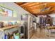 View of the large kitchen featuring stainless steel appliances, exposed ceiling beams, and a dining area at 330 W Minnezona Ave, Phoenix, AZ 85013