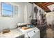 Laundry room showcasing the washing machine, an interesting art piece and exposed beams at 330 W Minnezona Ave, Phoenix, AZ 85013
