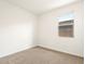 Bedroom with neutral carpet, white walls, and a window overlooking the neighborhood at 35459 N Seedling St, San Tan Valley, AZ 85144