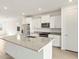 Bright kitchen boasts an island, stainless steel appliances, white cabinetry, and granite countertops at 35459 N Seedling St, San Tan Valley, AZ 85144