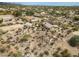 Drone shot of the property showing the horse arena, stalls, adjacent buildings, and desert terrain at 39606 N 3Rd Ave, Phoenix, AZ 85086