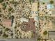 Birds-eye view of desert home with circular driveway, separate garage, horse arena, and native desert landscape at 39606 N 3Rd Ave, Phoenix, AZ 85086