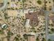 Birds-eye view of desert home with circular driveway, separate garage, horse arena, and native desert landscape at 39606 N 3Rd Ave, Phoenix, AZ 85086
