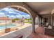 Covered patio with red tile floor and outdoor seating overlooking a backyard with a pool and grassy area at 412 W Curry St, Chandler, AZ 85225