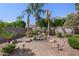 Tranquil backyard featuring a serene water feature surrounded by lush greenery and palm trees at 4340 S Marble St, Gilbert, AZ 85297