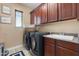 Modern laundry room with dark cabinets, sink, washer, and dryer for efficient cleaning at 4340 S Marble St, Gilbert, AZ 85297