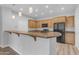 Open kitchen with wood cabinets, black appliances, stone countertops and bar seating at 4777 S Fulton Ranch Blvd # 1029, Chandler, AZ 85248