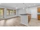 Open-concept living room with modern kitchen island, wood-style floors, and natural light at 4777 S Fulton Ranch Blvd # 1029, Chandler, AZ 85248