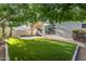 Serene backyard featuring artificial grass, mature trees, and a covered patio perfect for outdoor enjoyment at 4809 W Erie St, Chandler, AZ 85226