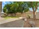 Spacious backyard with artificial turf, mature trees, and a concrete patio for outdoor enjoyment at 4809 W Erie St, Chandler, AZ 85226