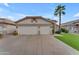 Inviting home featuring a wide driveway, spacious two-car garage, and a mature palm tree, enhancing its curb appeal at 4809 W Erie St, Chandler, AZ 85226