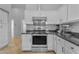 Bright kitchen featuring white cabinetry and stainless steel appliances, with a modern range hood above the stove at 4809 W Erie St, Chandler, AZ 85226