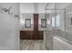 Ensuite bathroom featuring dual sinks, walk-in shower with glass door and grey tiled flooring at 4809 W Erie St, Chandler, AZ 85226