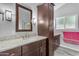 Ensuite bath offering wood-look flooring, granite counters, dual sink vanity and a walk-in shower at 4809 W Erie St, Chandler, AZ 85226