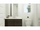 Bathroom with dark wood vanity, white countertops, toilet, window, and shower with white tiling at 5043 S 233Rd Dr, Buckeye, AZ 85326