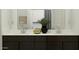 Modern bathroom featuring double vanity, dark wood cabinets, and a decorative mirror and stylish accessories at 5043 S 233Rd Dr, Buckeye, AZ 85326
