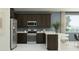 Modern kitchen featuring stainless steel appliances, dark wood cabinets, and a breakfast bar with seating at 5043 S 233Rd Dr, Buckeye, AZ 85326