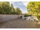 Spacious backyard with gravel, block fence, desert landscaping, firepit, and outdoor playhouse at 5206 S Clark Dr, Tempe, AZ 85283