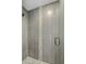 Shower stall with gray tile, decorative accent strip, pebbled shower floor and glass door at 5206 S Clark Dr, Tempe, AZ 85283