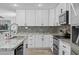 Updated kitchen featuring white cabinets, stone backsplash, and stainless-steel appliances at 5206 S Clark Dr, Tempe, AZ 85283