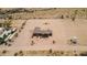 Aerial view of house with large flat desert landscape in background, big lot, and water tank at 54463 W Sunburst St, Maricopa, AZ 85139
