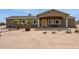 Charming single-story home featuring desert landscaping, a covered porch, and warm exterior lighting at 54463 W Sunburst St, Maricopa, AZ 85139