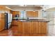 Large kitchen with wooden cabinets, granite countertops, stainless steel appliances, and terracotta tile flooring at 54463 W Sunburst St, Maricopa, AZ 85139