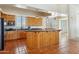 Large kitchen with wooden cabinets, granite countertops, stainless steel appliances, and terracotta tile flooring at 54463 W Sunburst St, Maricopa, AZ 85139