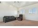 Bright living room with neutral carpet, white walls and comfortable furnishings at 54463 W Sunburst St, Maricopa, AZ 85139