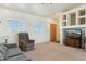 Bright living room with neutral carpet, white walls, a ceiling fan and a wall mounted media center at 54463 W Sunburst St, Maricopa, AZ 85139